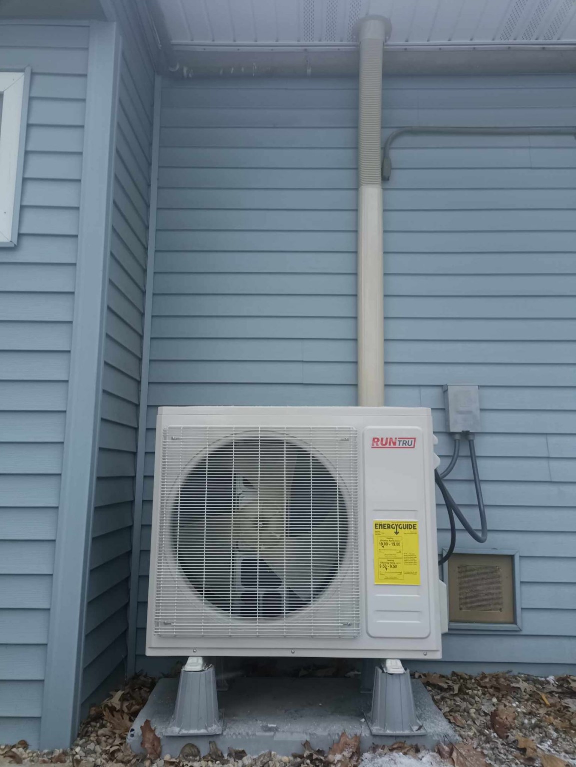 RunTru side-discharge condenser on risers with a lineset cover and disconnect
